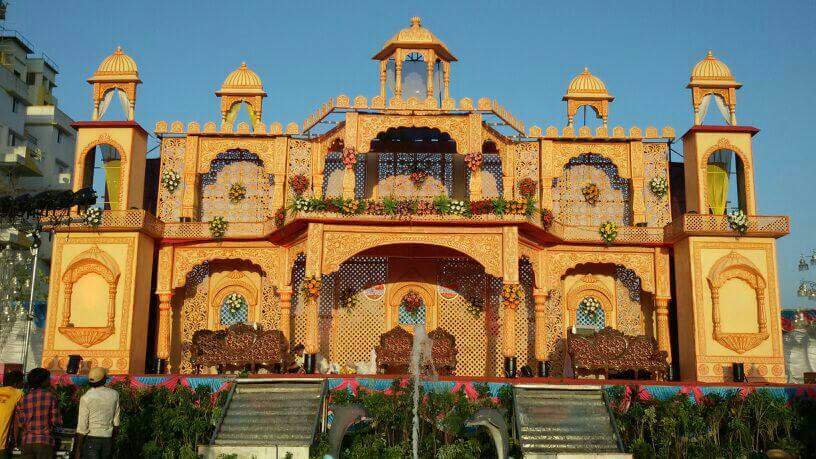 Royal palace-style wedding stage with traditional Rajasthani architecture, ornate carvings, domes, arches, and floral decorations for grand Indian wedding decor